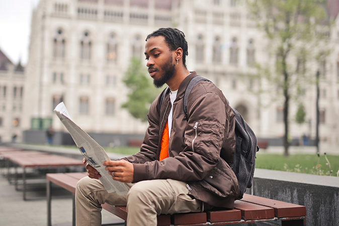 Young man reading newspaper article