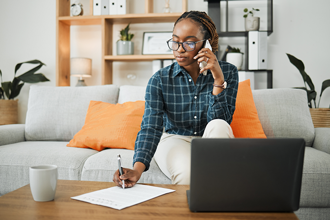 Young woman on phone writing article