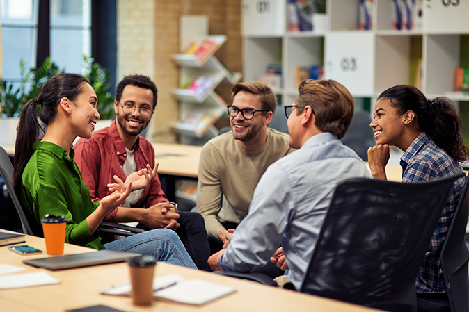 A multi-racial group of young professionals talking a circle