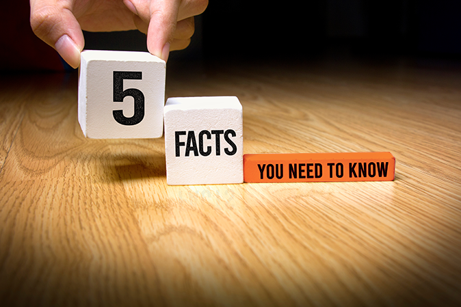 Person placing blocks on a table that says 5 facts you need to know