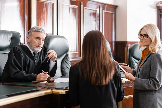 Two lawyers standing before a judge in a courtroom